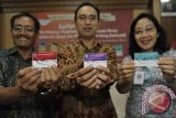 Koordinator Tim Pengendali Klaster 3 Skretariat TNP2K, Ari A Perdana (tengah) bersama Kepala Regional VIII PT Pos Indonesia, Wayan Santra (kiri) dan Kepala BPJS Kesehatan Divisi Regional XI Bali, NTB, NTT Ni Made Ayu Sri Ratna S (kanan) menunjukkan 3 kartu program peningkatan kesejahteraan masyarakat saat sosialisasi program pemerintah itu di Kuta, Bali, Jumat (14/11). Bali merupakan salah satu dari 10 provinsi yang menjadi target peluncuran tahap awal kartu tersebut sehingga nantinya secara bertahap dapat menyasar sekitar 150.000 keluarga kurang mampu di Pulau Dewata. ANTARA FOTO/Nyoman Budhiana/i018/2014.