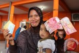 Warga menerima uang kompensasi kenaikan Bahan Bakar Minyak (BBM) bersubsidi sebesar Rp 400 ribu di Kantor Pos Banda Aceh, Kamis (20/11). Sebanyak 356.720 warga tidak mampu di Aceh menerima dana bantuan langsung sementara yang disalurkan melalui Program Simpanan Keluarga Sejahtera (PSKS). ANTARA FOTO/Ampelsa/wdy/14.