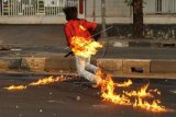 Seorang mahasiswa terbakar bom molotov miliknya sendiri saat terjadi bentrokan antara polisi dan mahasiswa di kampus Universitas Negeri Makassar (UNM), Sulawesi Selatan, Rabu (19/11). Bentrokan terjadi ketika polisi berusaha membubarkan aksi tutup jalan mahasiswa yang menolak kenaikan harga BBM. ANTARA FOTO/Abriawan Abhe/YU/ss/Spt/14