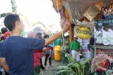 Seorang pengunjung memilih barang yang dipamerkan di salah satu stand pameran milik SDN Alalak Selatan di ajang "Green Festival" 2014 yang diikuti sekolah SD-SLTA se-Kota Banjarmasin adakan oleh Forum Komunitas Hijau (FKH Banjarmasin di Siring Sungai Martaputa jalan P Tendean, Banjarmasin, MInggu (23/11).(Foto Antaranews Kalsel/Asmuni K/e)