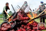 Petugas kepolisian dan Bea Cukai membakar bawang ilegal jenis bombai di Lhokseumawe, Provinsi Aceh. Senin (24/11). Sebanyak 30 ton bawang ilegal dimusnahkan hasil tangkapan polisi saat mengagagalkan penyeludupan bawang melalui perairan Selat Malaka di kawasan Samudera Geudong. ANTARA FOTO/Rahmad/Rei/ama/14.