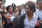 Menteri Kelautan dan Perikanan Susi Pudjiastuti memegang pipi seorang anak nelayan, dalam kunjungan mendampingi Presiden Joko Widodo ke perkampungan nelayan Kelurahan Malabro, Kota Bengkulu, Rabu (26/11). Susi mengingatkan pemerintah setempat jika masih ada trawl, tidak akan ada bantuan. ANTARA FOTO/Boyke LW/wdy/14.