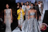 Perancang busana Tex Saverio (tengah) bersama model berjalan di panggung peragaan busana usai membawakan busana koleksinya Spring Summer 2015 dalam perhelatan Jakarta Fashion Week 2015 di Jakarta, Sabtu (1/11). Koleksi yang telah ditampilkan di Paris Fashion Week pada September lalu tersebut memiliki tema Parametric yang memadukan bentuk geometris tanpa melupakan feminimitas, menciptakan sebuah gaya futuristik yang romantis. ANTARA FOTO/Teresia May/MFD/14