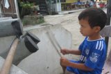 Samosir, 26/11 - LATIHAN MEMUKUL GENDANG. Seorang anak latihan memukul gendang yang terbuat dari bahan sederhana berupa pipa plafon dan karet ban, di Pantai Pasir Putih, Kabupaten Samosir. Bakat seni musik diperoleh pelajar Kelas 1 SD ini dari ayahnya, yang seharian bermain musik untuk acara adat etnis Batak. (Foto Antarasumut/Waristo)