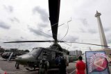 Pengunjung memperhatikan sebuah helikopter milik TNI AD pada Pameran Alat Utama Sistem Persenjataan (Alutsista) TNI AD di Silang Monas, Jakarta, Jumat (12/12). Pameran yang menampilkan 200 jenis peralatan tempur diantaranya persenjataan infanteri, kavaleri, artileri medan dan pertahanan udara itu diselenggarakan dalam rangka memperingati Hari Juang Kartika Ke-69 yang berlangsung pada 12-15 Desember. ANTARA FOTO/Muhammad Adimaja/wdy/14.