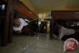 Pelajar Sekolah Dasar melindungi kepala dengan tas dan berlindung dibawah meja saat mengikuti simulasi bencana gempa dan tsunami di SD Negeri 2, Banda Aceh, Senin (15/12). Simulasi bencana gempa dan tsunami yang dilaksanakan setiap tahun sekaligus menyambut 10 tahun tsunami Aceh juga mendidik serta melatih pelajar dalam kesiapsiagaan dan meminimalkan dampak bencana. ANTARA FOTO/Irwansyah Putra/Rei/pd/14.