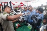 Seorang staf Penerangan Kodam (Pendam) XVI/Pattimura menjelaskan fungsi pesawat APW Drone milik Penerangan Kondam (Pendam) yang biasa digunakan untuk tugas topografi, pada pameran Alat Utama Sistem Persenjataan (Alutsista) Tentara Nasional Indonesia (TNI) Angkatan Darat (AD) di Ambon, Senin (15/12). Pameran yang digelar untuk memperingati Hari Juang Kartika ini menampilkan ratusan unit peralatan tempur, termasuk pesawat APW Drone milik Pendam XVI/Pattimura yang sangat menarik perhatian pengunjung. ANTARA FOTO/Embong Salampessy/ed/ama/14.