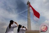 Sejumlah anggota PMI memberi hormat saat pengibaran Bendera Merah Putih raksasa di tugu Monas, Jakarta, Jumat (19/12). Pengibaran bendera Merah Putih tersebut merupakan puncak dari acara peringatan Hari Bela Negara sekaligus tercatat dalam rekor dunia dengan kategori bendera terbesar didunia dengan ukuran 2.250 m2. ANTARA FOTO/Muhammad Adimaja/wdy/14.