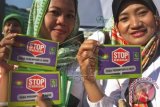 Dua aktivis perempuan bangsa memegang stiker ketika menggelar kampanye menyambut Hari Ibu pada Hari Bebas Kendaraan Bermotor di Jalan M.H. Thamrin, Jakarta, Minggu (21/12). Mereka memprotes kekerasan yang masih sering terjadi terhadap kaum perempuan. ANTARA FOTO/Reno Esnir

