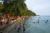 Sejumlah pengunjung menikmati suasana di Pantai Natsepa, Ambon, Maluku, Minggu (28/12). Pantai Natsepa merupakan salah satu destinasi wisata andalan di Pulau Ambon, dan menjadi tempat favorit saat liburan akhir tahun. ANTARA FOTO/Embong Salampessy/Rei/ama/14.