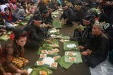 Banyuwangi (Antara Jatim) - Sejumlah warga memakan nasi tumpeng dalam 