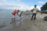 <br />
<br />
Samosir, 7/12 - BERMAIN PASIR. Seorang ayah menyaksikan isteri dan anaknya bermain pasir di objek wisata Pasir Putih Parbaba, Kabupaten Samosir, Minggu. Objek wisata ini ramai dikunjungi karena pengunjung bisa menikmati pantai dan air Danau Toba sampai sejauh 100 meter. Pengelola menyediakan fasilitas air sehingga menambah daya jual wisata daerah ini. (Foto Antarasumut/Waristo)