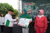    Surabaya (Antara Jatim) - Kepala Dinas Kesehatan Provinsi Jawa Timur dr Harsono (kiri) memberikan hadiah kepada perwakilan kelurahan memperingati Hari Osteoporosis Nasional di Parkir Timur Plaza Surabaya, Minggu (25/1). Pemprov Jatim mengimbau masyarakat tidak berhenti bergerak setiap harinya untuk menghindari dan mencegah ancaman penyakit osteoporosis atau tulang keropos. FOTO Fiqih Arfani