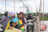 Beberapa warga melewati jembatan gantung yang membentang diatas Sungai Martapura, Desa Tandipah, Kamis (1/1) pada tahun baru 2015. Jembatan dengan panjang sekitar 400 dan lebar dua meter tersebut dibangun oleh Pemkab Banjar melalui program PNPM 2018 untuk menguhungkan Desa Tandipah dan Sungai Lulut terlihat sudah tua dan disana-sini bagian pagar bilah besinya banyak yang karat dan patah.Foto Antranews Kalsel/Asmuni/e)