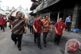 Menteri Perdagangan, Rachmat Gobel (dua dari kanan) dan Menteri Koperasi, Anak Agung Gede Ngurah Puspa Yoga (kiri) meninjau ke lokasi kebakaran Pasar Klewer, Solo, Jawa Tengah, Sabtu, (3/1). Mendag mengatakan akan segera mengambil langkah agar Pasar Klewer kembali beroperasi serta menggandeng Kementerian Koperasi untuk mengurangi dampak kerugian dari berhentinya perdagangan. ANTARA FOTO/Maulana Surya/wdy/15.