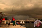 Warga memancing saat awan tebal menyelimuti wilayah udara  di pelabuhan wisata Ulee Lheue, Banda Aceh, Jumat (9/1). Badan Meteorologi, Klimatologi dan Geofisika Aceh menyatakan cuaca ekstrim disertai hujan dan guntur akan berlangsung selama  sepekan mendatang di daerah tersebut. ANTARAACEH.COM/Ampelsa/14