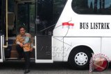 Direktur Utama PT Sarimas Ahmadi Pratama Dasep Ahmadi berpose di pintu bus listrik buatan perusahaannya yang diparkir di halaman Balai Kota, Jakarta, Kamis (15/1). Bus buatan PT Sarimas Ahmadi Pratama tersebut diperkenalkan kepada Pemprov DKI Jakarta dan diharapkan dapat menjadi sarana transportasi massal di Jakarta. ANTARA FOTO/Zabur Karuru/wdy/15