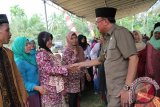 Jambi - Bupati Batanghari Sinwan SH, menyempatkan menyalami warga saat menghadiri acara Maulid Nabi Muhammad SAW di Desa Ladang Peris, Kecamatan Bajubang pada Rabu (21/1).(FOTO Antarajambi.com/Heriyanto) 