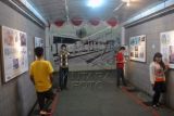 Sejumlah pengunjung berfoto saat Pameran Lukisan Sketsa Bogor di Galeri Jembatan Underpass, jalan raya Pajajaran, Kota Bogor, Jabar. (Foto Antara/Arif Firmansyah)
