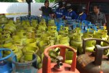 PASURUAN (Antara Jatim) : Dua polisi dari Satuan Reskrim Polres Pasuruan menunjukan barang bukti ratusan tabung elpiji dan tiga tersangka, saat gelar perkara pengoplosan LPG, di Polres Pasuruan, Jatim, Selasa (27/1). Dalam kasus tersebut modus pelaku memindahkan isi elpiji dari tabung 3kg yang bersubsidi ke tabung 12kg atau 50kg non subsidi, saat ini Polres Pasuruan masih melakukan pengejaran satu pelaku yang menjadi DPO (Daftar Pencarian Orang). ANTARA FOTO/Adhitya Hendra/15.