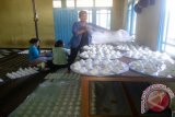 Ibu Subekti sedang menyiapkan produksi bakpao di rumahnya bersama karyawannya.