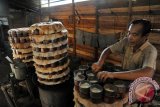 Pembuat Kue Keranjang, Acuan (55) menata tumpukan kaleng cetakan berisi adonan Kue Keranjang yang terbuat dari beras ketan dan gula pasir, di kediamannya di Jalan Veteran Pontianak, Kalbar, Jumat (13/2). Kue Keranjang untuk perayaan Imlek yang dijual seharga Rp22 ribu per kilogram dan diproduksi oleh usaha rumahan Tan Ngen Cuang sejak 42 tahun lalu tersebut, didistribusikan di Kota Pontianak serta beberapa kabupaten di Kalbar. FOTO ANTARA/Jessica Helena Wuysang/mes/15