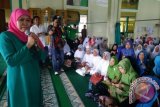 Menteri Sosial Republik Indonesia Khofifah Indar Parawansa memberikan bantuan kepada fakir miskin, janda dan jompo serta menyampaikan tausiyah pada peringatan maulid nabi Muhammad SAW di Masjid Jami Pontianak pada Minggu (15/2). (Foto Antara Kalbar / Rendra Oxtora)