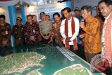 Presiden Joko Widodo (tengah) didampingi Menko Perekonomian Sofyan Jalil (kiri) Plt Gubernur Banten Rano Karno (kanan) melihat maket pengembangan Kawasan Ekonomi Khusus (KEK) Pariwisata Tanjung Lesung, di Desa Tanjung Jaya, Pandeglang, Banten, Senin (23/2). Presiden Jokowi menjanjikan pembangunan jalan tol Serang - Tanjung Lesung sejauh 80 kilometer akan bisa diselesaikan dalam tiga tahun dan meminta proses penyelesaian sarana wisata dan pendukungnya harus pula diselesaikan dalam tempo tersebut. ANTARA FOTO/Asep Fathulrahman/wdy/15.