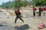 Anggota TNI menggendong pelajar SD menyeberang sungai karena jembatan hanyut diterjang banjir di Desa Segulung, Kec. Dagangan, Kab. Madiun, Jatim, Senin (23/2). Sejak banjir bandang yang menghanyutkan satu-satunya jembatan di desa tersebut, Kamis (19/2), pelajar dan warga terpaksa menyeberangi sungai kalau tak ingin memutar lewat jembatan lain dengan jarak 15 km lebih jauh. ANTARA FOTO/Siswowidodo/Rei/ama/15