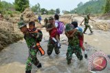 Anggota TNI menggendong pelajar SD menyeberang sungai karena jembatan hanyut diterjang banjir di Desa Segulung, Kec. Dagangan, Kab. Madiun, Jatim, Senin (23/2). Sejak banjir bandang yang menghanyutkan satu-satunya jembatan di desa tersebut, Kamis (19/2), pelajar dan warga terpaksa menyeberangi sungai kalau tak ingin memutar lewat jembatan lain dengan jarak 15 km lebih jauh. ANTARA FOTO/Siswowidodo/Rei/ama/15.