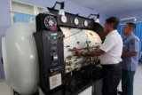 Sejumlah petugas memantau pengoperasian peralatan 'Hyperbaric Chamber' di RS TNI Angkatan Laut FX. Soehardjo, Pangkalan Utama TNI Angkatan Laut (Lantamal) IX Ambon, Maluku, Kamis (26/2). Jajaran rumah sakit tersebut berhasil melakukan perbaikan dan rekondisi 'Hyperbaric Chamber' atau kamar oksigen betekanan tinggi yang dapat digunakan untuk terapi sejumlah penykit itu setelah empat tahun tidak digunakan. ANTARA FOTO/Izaac Mulyawan/Rei/15.