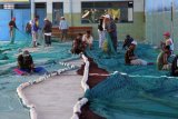 Trenggalek (Antara Jatim) - Sejumlah nelayan memperbaiki jaring pukat harimau di sisi dermaga Pelabuhan Perikanan Pantai Prigi, Trenggalek, Jawa Timur, Senin (23/2). Perbaikan jaring ratusan meter tersebut menghabiskan biaya antara Rp. 5 juta hingga Rp. 10 juta yang di siapkan untuk kegiatan melaut nelayan untuk menangkap ikan pada saat cuaca dan gelombang laut mendukung. FOTO Rudi Mulya/15/Chan.