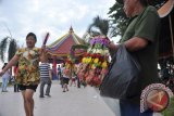 Penjual rangkaian bunga menawarkan dagangannya di kawasan Pulo Kemaro Palembang, Senin (2/3). Jelang puncak peringatan Cap Go Meh yang jatuh pada 4 Maret mendatang pengunjung dan pedagang mulai meramaikan kawasan pulau kecil yang menjadi tempat perayaan puncak malam cap go meh 2566 itu. ANTARA FOTO/ Feny Selly/ss/pd/15