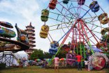 Sejumlah anak memperhatikan bianglala yang didirikan untuk meramaikan malam cap go meh di kawasan Pagoda Pulo Kemaro Palembang, Senin (2/3). Jelang puncak peringatan Cap Go Meh yang jatuh pada 4 Maret mendatang pengunjung dan pedagang mulai meramaikan kawasan pulau kecil yang menjadi tempat perayaan puncak malam cap go meh 2566 itu. ANTARA FOTO/ Feny Selly/ss/pd/15