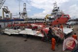 Petugas memeriksa badan pesawat AirAsia QZ8501 di Pelabuhan Tanjung Priok, Jakarta Utara, Senin (2/3). Badan pesawat tersebut selanjutnya diserahkan kepada Komite Nasional Keselamatan Transportasi (KNKT) untuk dilakukan penyelidikan. ANTARA FOTO/Zabur Karuru/pd/15