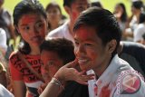 Seorang anak mendapat coretan warna-warni di wajahnya saat festival Holi khas India di Denpasar, Bali, Minggu (15/3). Festival budaya yang diprakarsai Konsulat Jendral India di Bali tersebut bertujuan untuk mempererat persaudaraan Indonesia-India khususnya di Bali. Antara Foto/Nyoman Budhiana/i018/15.