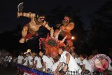 Sejumlah pemuda mengarak Ogoh-Ogoh atau boneka raksasa yang melambangkan sifat-sifat buruk dalam Festival Ogoh-Ogoh 2015 menjelang Hari Raya Nyepi Tahun Saka 1937 di Desa Tegallalang, Gianyar, Bali, Kamis (19/3). Parade Ogoh-Ogoh tersebut untuk menetralisir kekuatan negatif dan sifat buruk sehingga Hari Raya Nyepi dapat dilaksanakan dengan penuh keheningan dan kedamaian. ANTARA FOTO/Nyoman Budhiana/i018/2015.