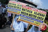 Dua pelajar membawa poster imbauan untuk mematikan mesin kendaraan ketika berlangsungnya aksi Hari Meteorologi di Jl. Demak, Surabaya, Jatim, Senin (23/3). Para pelajar tersebut menghimbau masyarakat untuk peduli dalam menyelamatkan lapisan ozon yang semakin rusak. (ANTARA FOTO/Bima)