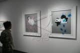 Seorang pengunjung memperhatikan 2 lukisan karya berjudul "Mother of Wild" karya Marishka Soekarna pada acara penutupan pameran seni rupa kontemporer bertajuk "Medium of Living", di Galeri Edwin, Jakarta Selatan, Minggu (22/3). Pameran yang diikuti oleh 5 perupa kontemporer itu dipamerkan sejak 11 Maret 2015 lalu di galeri tersebut. ANTARA FOTO/Dodo Karundeng/NZ/15.
