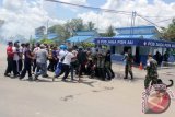 Puluhan demontran melakukan aksi blokir pintu gerbang Markas Komando Pangkalan Udara Sjamsudin Noor Banjarbaru, Selasa (24/3). Lanud SAM menggelar simulasi pertahanan pangkalan untuk meningkatkan kesiagaan personil terhadap ancaman yang datang sewaktu-waktu. Foto Antaranews Kalsel/Dispen SAM-Herry Murdy Hermawan