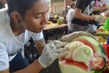 Peserta mengukiran semangka saat berlangsungnya lomba mengukir buah dan sayur di Kota Denpasar, Bali, Sabtu (28/3). Lomba yang diikuti puluhan peserta tersebut untuk mengapresiasi seni mengukir buah sehingga terciptanya karya seni ukir buah yang inovatif. ANTARA FOTO/Fikri Yuuf/wdy/15.