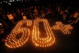 Kelompok "Earth Hour" Padang bersama warga membakar lilin membentuk angka 60 plus saat peringatan "Earth Hour 2015" di Bundaran Taman Melati, Padang, Sumatera Barat, Sabtu (28/3). Aksi dengan mematikan lampu selama 60 menit itu, digelar serentak di sejumlah kawasan strategis di kota itu dengan tajuk "Padang Kalam". ANTARA FOTO/Iggoy el Fitra/Asf/pras/15.