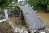 Madiun (Antara Jatim) - Warga berada di dekat jembatan yang runtuh di Desa Kedondong, Kec. Kebonsari, Kab. Madiun, Selasa (31/3). Jembatan tersebut ambrol akibat diterjang banjir dan mengakibatkan terganggunya aktivitas warga di sejumla desa. FOTO Siswowidodo/15/Chan.

