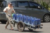 Surabaya (Antara Jatim) - Pekerja mendorong gerobak dengan muatan jeriken berisi air bersih, guna diantarkan kepada warung langganannya, di Jalan Kombes Pol. M. Duryat, Surabaya, Minggu (22/3). Bertepatan dengan Hari Air Se-dunia yang jatuh pada tanggal 22 Maret 2015, Kementerian Pekerjaan Umum dan Perumahan Rakyat (PUPR) mengajak semua lapisan masyarakat akan pentingnya  menjaga dan melestarikan sumber air. (Foto Saiful Bahri/15/edy)