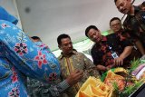 Mojokerto (Antara Jatim) - Arief Mulyadi Executive Vice President PT PNM (Permodalan Nasional Madani) Persero (tengah) bersama anggota Komisi VI DPR RI Suryo Alam (kiri) dan Pimpinan PT PPNM Cabang Surabaya Puji Riyanto (kanan) melihat hasil produksi UMK binaan usai serah terima dan penutupan program pengembangan kapasitas usaha klasterisasi industri UMK perajin perak dan suasa di Balai Desa Batan Krajan, Gedeg, Mojokerto, Jawa Timur, Kamis (12/3). Program Pengembangan Kapasitas Usaha (PKU) klasterisasi perajin perak dan suasa melalui pelatihan dan pendampingan yang telah diadakan setahun lebih ini diharapkan dari sisi pemasaran dan jaringan usaha UMK nasabah ULaMM PNM mampu mengoptimalkan pasar lokal sekaligus pasar regional serta pasar global untuk mengembalikan kejayaan usaha kerajinan perak dan suasa sebelum peristiwa Bom Bali. (FOTO Syaiful Arif/15/edy)