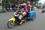 Bojonegoro (Antara Jatim) - Sepasang suami istri dengan berkendaraan sepeda motor melintas di jalanan di Kabupaten Bojonegoro, Jawa Timur, dengan menyeret gerobak dan membawa anaknya, Senin (30/3). Cara yang dilakukan dalam membawa gerobak tersebut, cukup berbahaya, juga bagi pengendara kendaraan bermotor lainnya. FOTO Slamet Agus Sudarmojo/15/Oka..