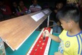 Bojonegoro (Antara Jatim) - Seorang anak kecil melihat batu akik untuk memberikan penilaian, dalam kontes 