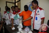 Tersangka Ansur bin Sanudi (33 tahun) menuangkan cairan narkoba jenis sabu yang sudah diblender sebelum dibuang ke kloset, disaksikan sejumlah petugas BNN Kaltim di Samarinda, Kamis (2/4). Tersangka bersama Rudi alias Isra terancam hukuman mati atas kepemilikan sabu-sabu seberat 2 kilogram. (ANTARA Kaltim/Adi Sagaria)
