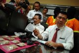 Dir Narkoba Polda Riau, Kombes Pol Hermansyah (kanan) menunjukan barang bukti pil ekstasi hasil tangkapan beserta dua tersangka pengedar pil ekstasi sebanyak 1100 butir saat paparan hasil tangkapan di ruangan Direktorat Reserse Narkoba Polda Riau di Pekanbaru, Riau, Senin (6/4). Kedua tersangka diamankan petugas Direktorat Reserse Narkoba Polda Riau di kediamannya dikawasan Marpoyan Damai, disaat hendak menjual pil ekstasi tersebut dengan nilai 300 jutaan rupiah. ANTARA FOTO/Rony Muharrman/ss/nz/15