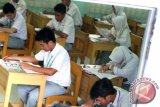 Beberapa peserta mengerjakan soal ujian nasional di satu ruang di SMAN 2 Banjarmasin, Senin (13/4). Pelaksanaan UN 2015 di Banjarmasin berlangsung lancar dan diikuti 8.106 siswa SMA sederajat. Foto Antaranews Kalsel/Herry Murdy Hermawan
